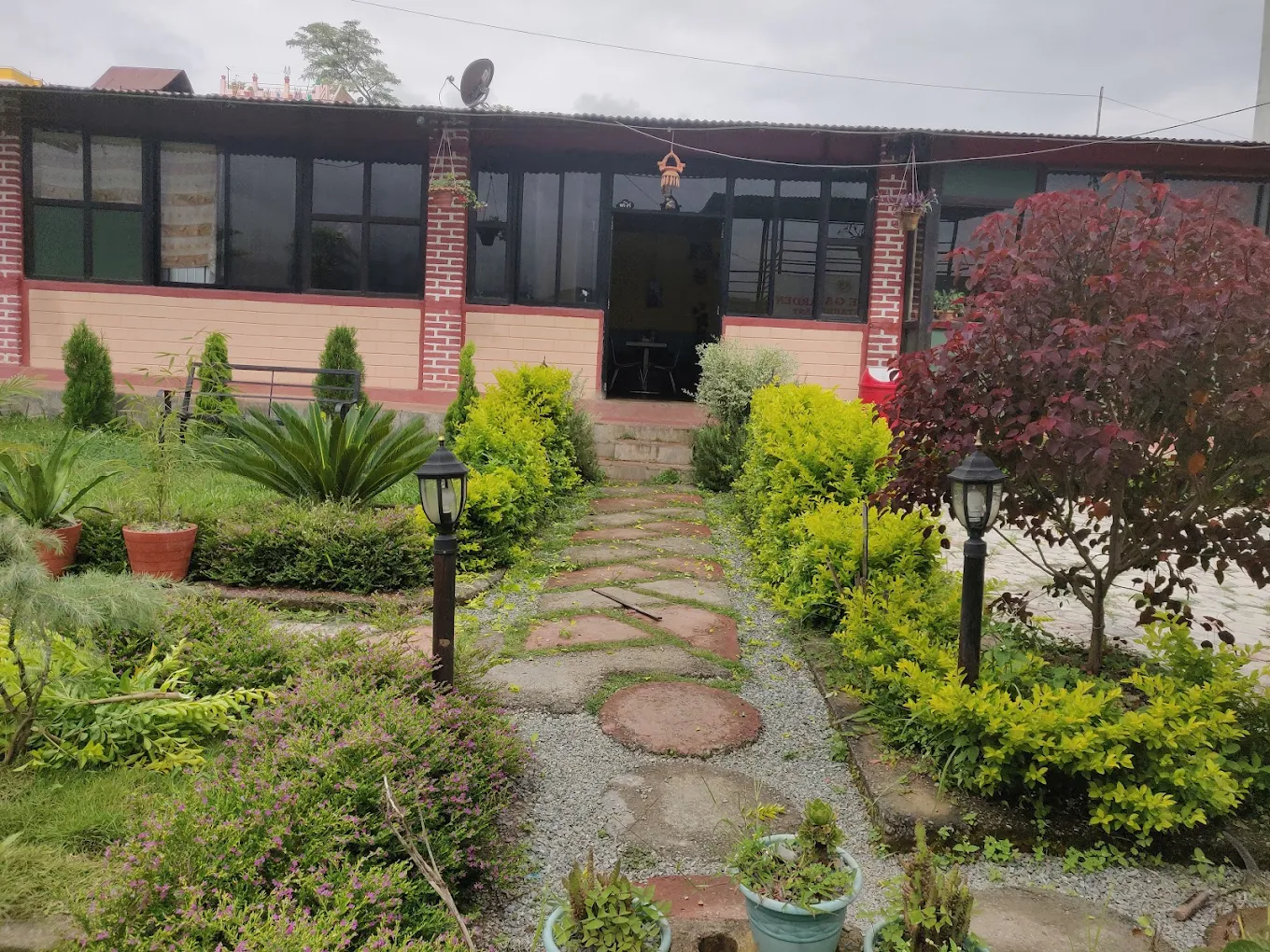 Peace Garden Restaurant Thecho front entrance with garden lamps and greenery